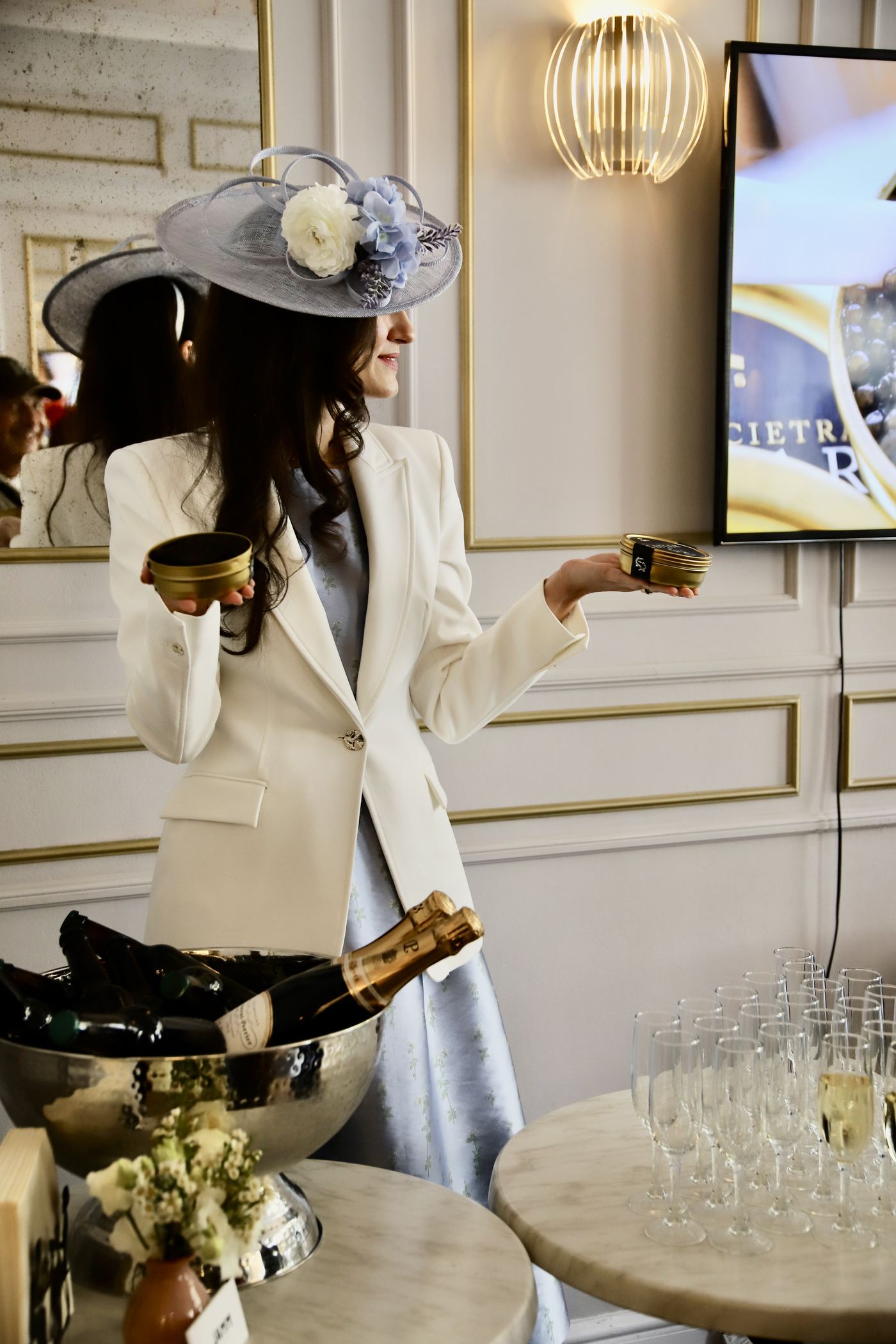 A guest with tins of Attilus caviar beside the champagne.
